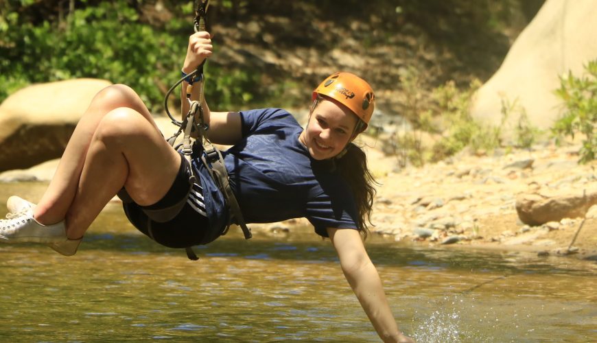 Girl at Canopy Tour touching the river at Canopy River Ziplines